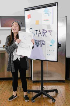 entrepreneur standing next to white board
